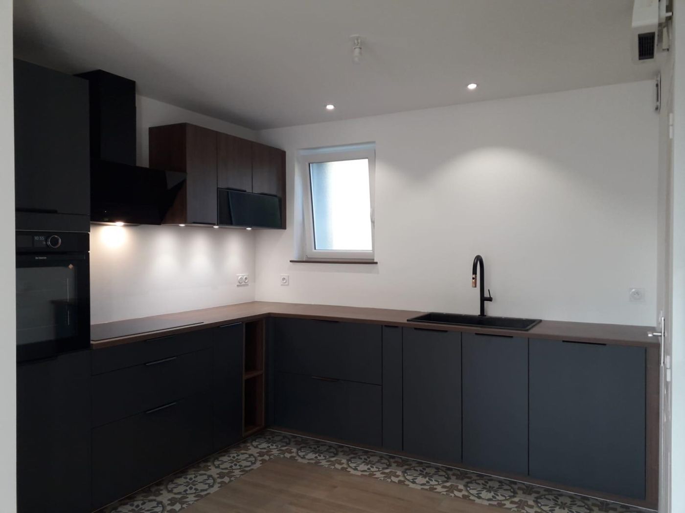 Cuisine noire mate sur sol en carreaux ciment